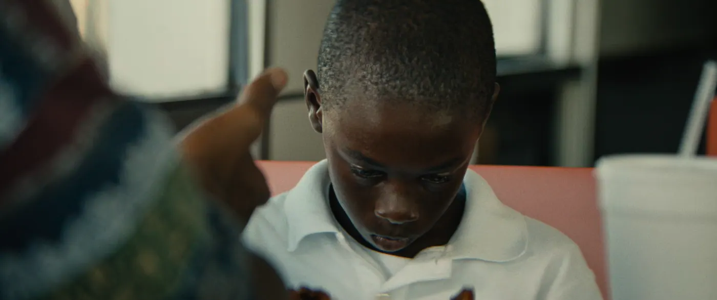 Moonlight (2016), Barry Jenkins — plan rapproché, jour, intérieur, deux personnages : restaurant, polo blanc, gobelet, paille