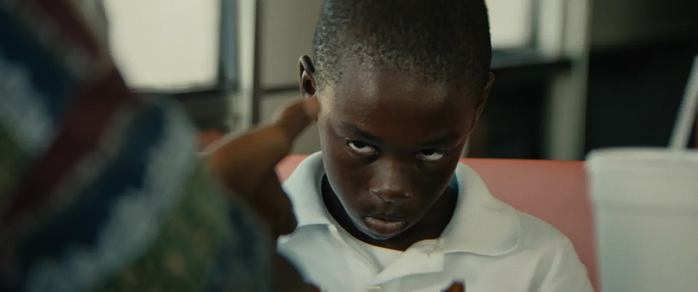 Moonlight (2016), Barry Jenkins — plan rapproché, jour, intérieur, deux personnages : restaurant, polo blanc, gobelet, paille