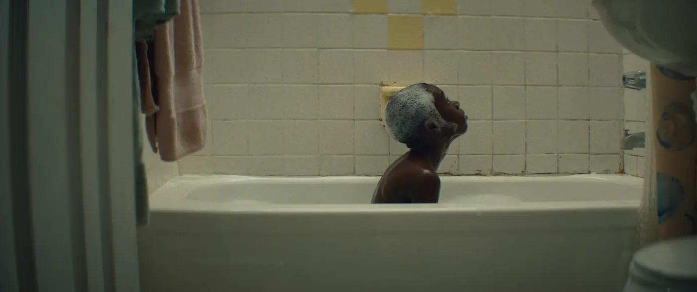 Moonlight (2016), Barry Jenkins — plan large, intérieur, un personnage, lumière froide : salle de bain, baignoire, savon, porte-savon, serviette, rideau de douche, prendre un bain
