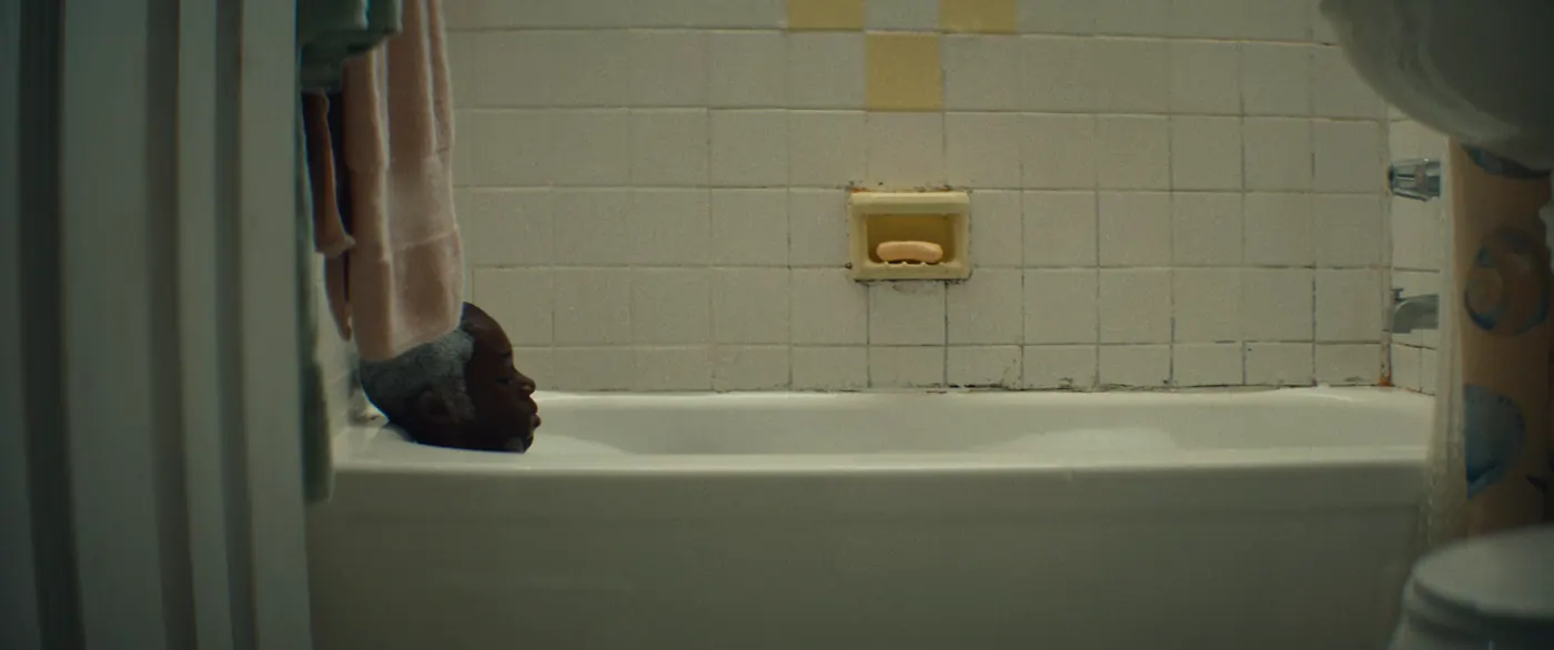 Moonlight (2016), Barry Jenkins — plan large, intérieur, un personnage, lumière froide : salle de bain, baignoire, savon, porte-savon, serviette, rideau de douche, prendre un bain