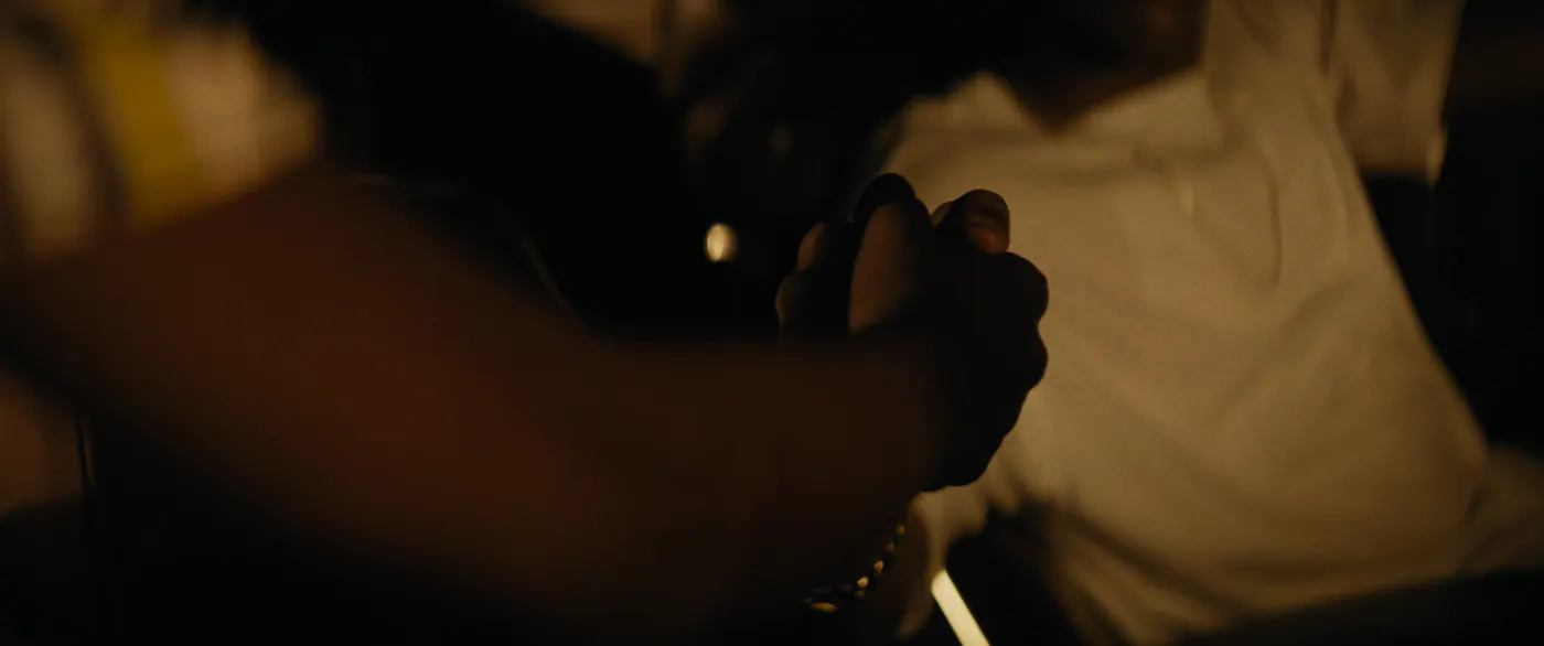 Moonlight (2016), Barry Jenkins — très gros plan, deux personnages, clair-obscur, lumière chaude : bracelet, tee-shirt, serrer la main