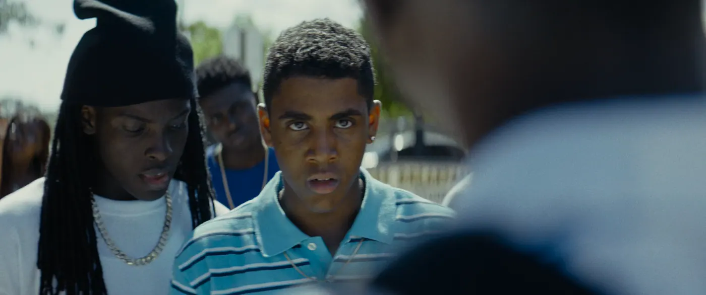 Moonlight (2016), Barry Jenkins — plan rapproché, jour, extérieur, cinq personnages : polo bleu, bonnet noir, collier, boucle d’oreille, polo rayé