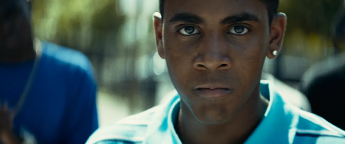 Moonlight (2016), Barry Jenkins — gros plan, jour, extérieur, trois personnages : polo bleu, boucle d’oreille, polo rayé