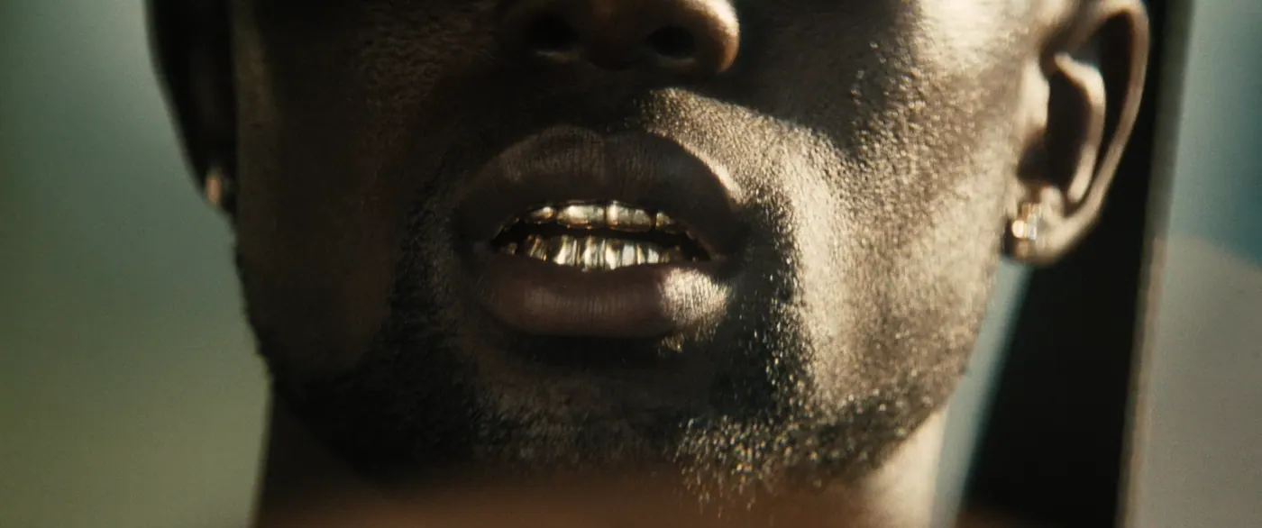 Moonlight (2016), Barry Jenkins — très gros plan, un personnage, lumière chaude : grillz, dents en or, boucle d’oreille