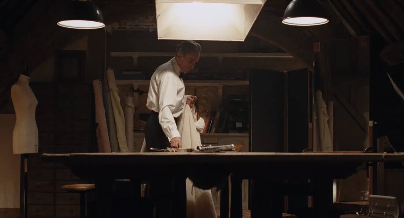 Phantom Thread (2017), Paul Thomas Anderson — plan large, intérieur, un personnage, clair-obscur : atelier de couture, grenier, mannequin de couture, table, lampe, rouleau de tissu, tissu