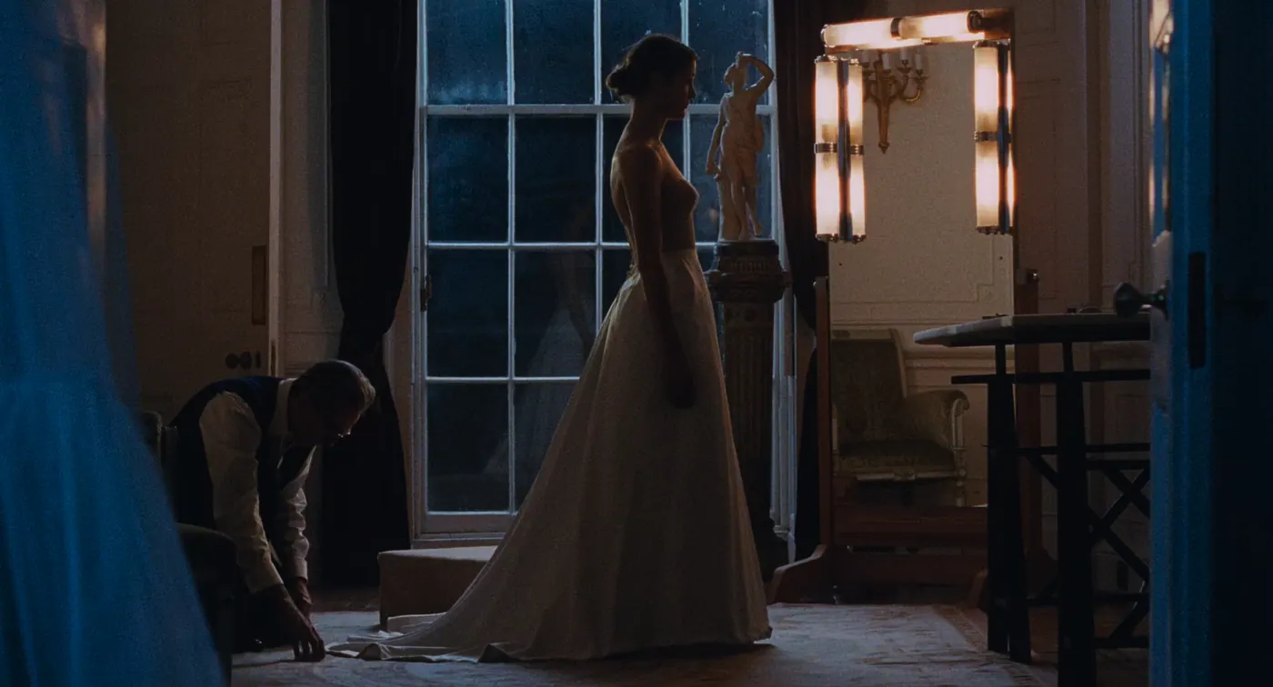 Phantom Thread (2017), Paul Thomas Anderson — plan large, nuit, intérieur, deux personnages, lumière froide, lumière chaude : salon, robe blanche, statue, fenêtre, rideau, applique, fauteuil