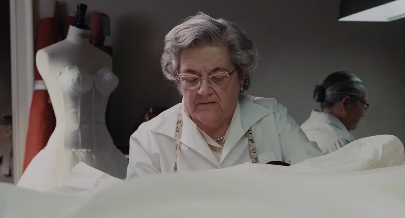 Phantom Thread (2017), Paul Thomas Anderson — plan rapproché, intérieur, deux personnages : atelier de couture, blouse blanche, mannequin de couture, mètre ruban, tissu, rouleau de tissu