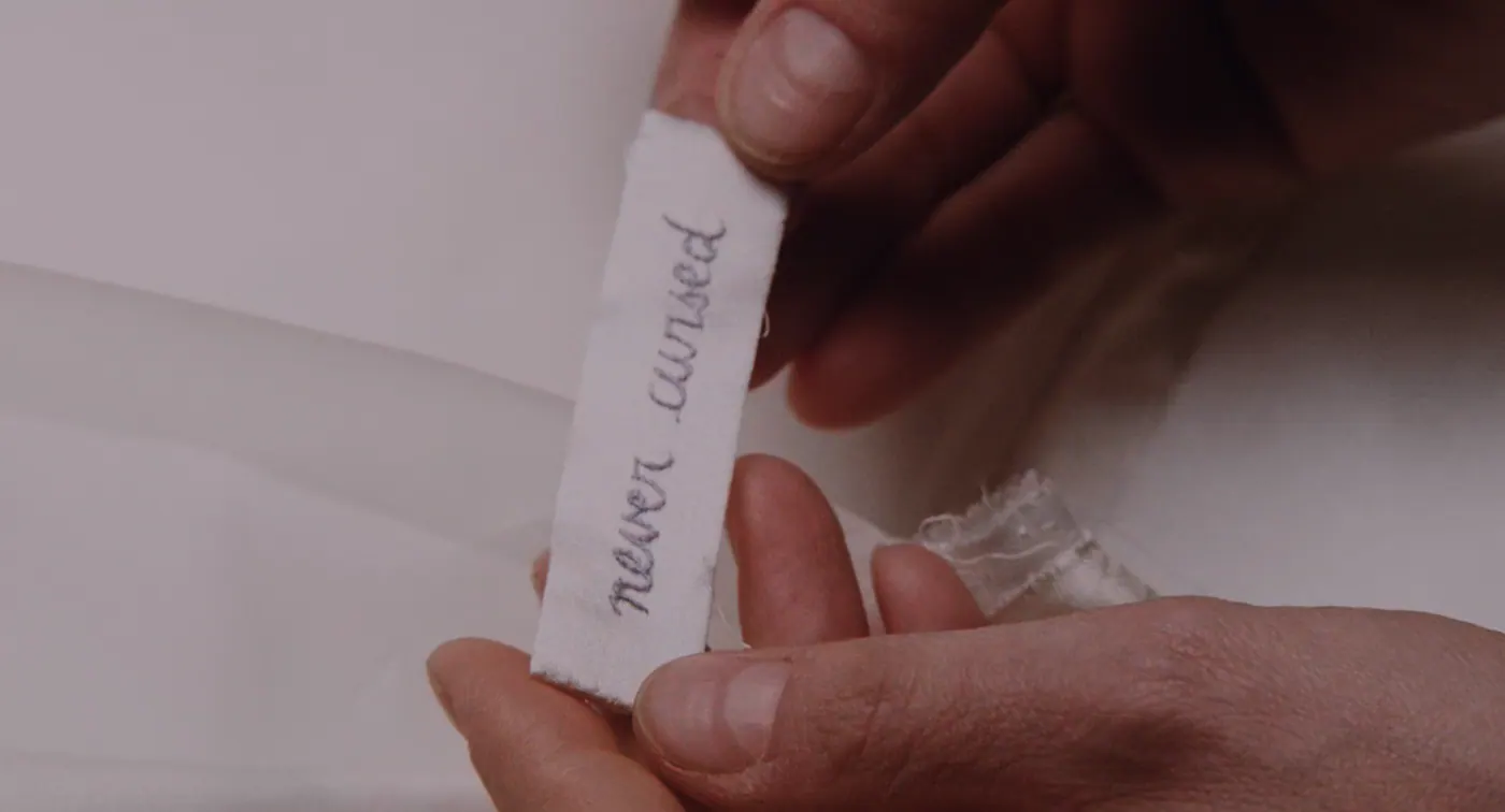 Phantom Thread (2017), Paul Thomas Anderson — très gros plan, un personnage : étiquette brodée, tissu