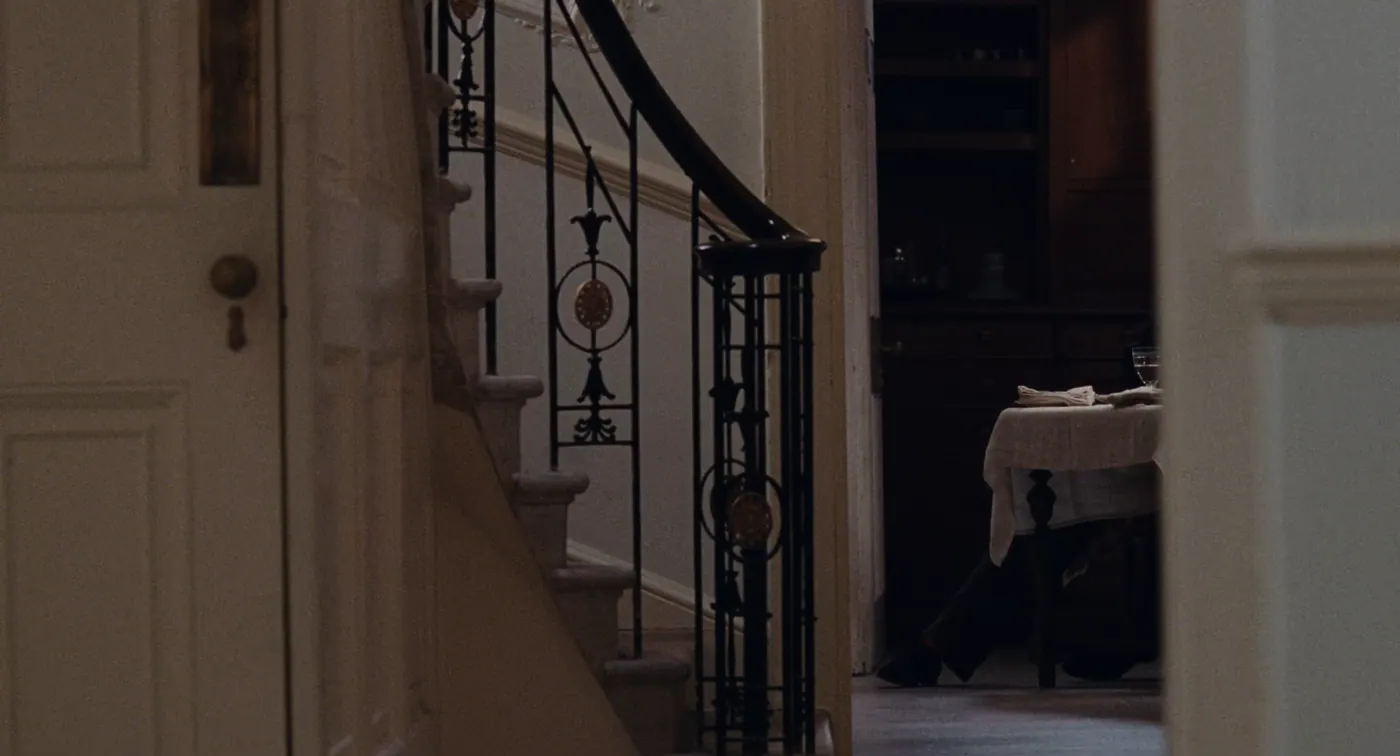 Phantom Thread (2017), Paul Thomas Anderson — plan large, intérieur, un personnage : escalier, couloir, rampe en fer forgé, porte, table, nappe, verre