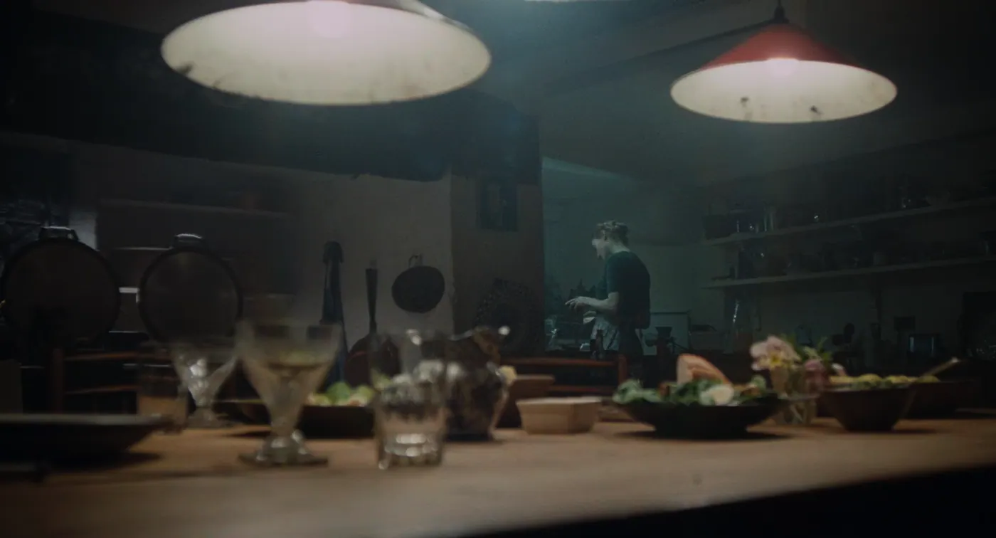 Phantom Thread (2017), Paul Thomas Anderson — plan large, intérieur, un personnage, clair-obscur, lumière froide : cuisine, lampe, verre, bouteille, saladier, légume, tablier, cuisiner
