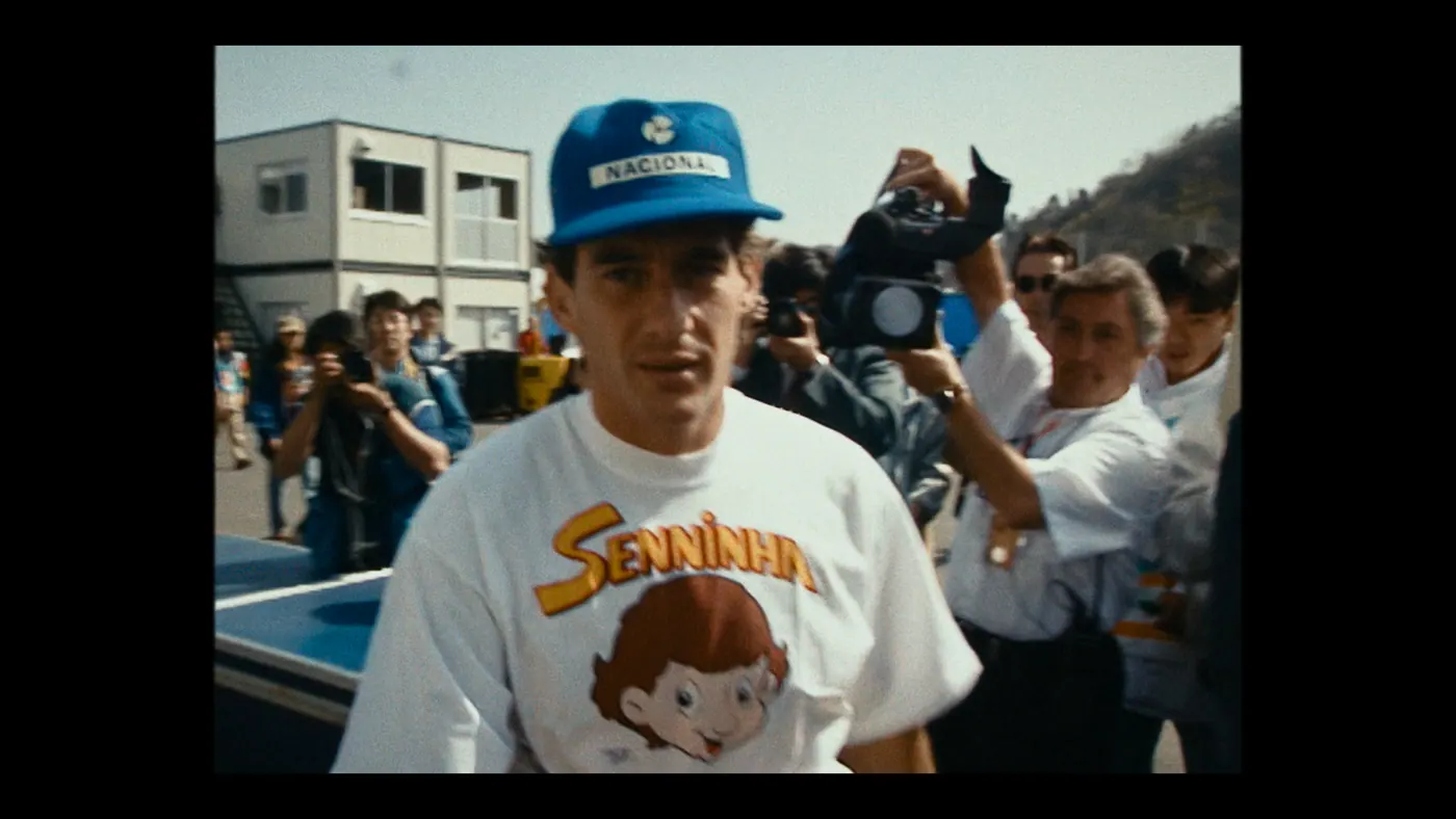 Schumacher ’94 — The Birth of a Legend (2026), Christin Freitag — plan rapproché, jour, extérieur, foule, soleil direct : paddock, circuit automobile, casquette bleue, tee-shirt blanc
