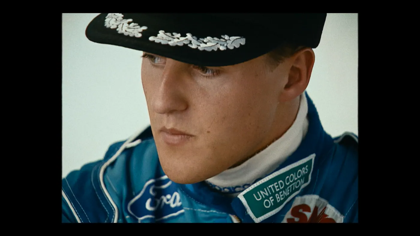 Schumacher ’94 — The Birth of a Legend (2026), Christin Freitag — gros plan, un personnage : casquette noire, combinaison bleue, combinaison de pilote