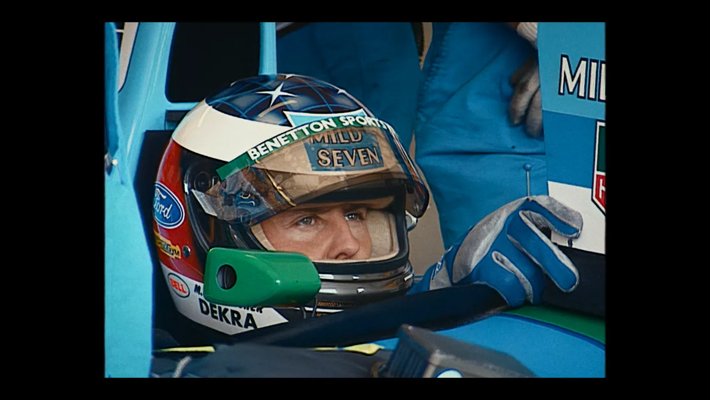 Schumacher ’94 — The Birth of a Legend (2026), Christin Freitag — gros plan, deux personnages : voiture (habitacle), voiture de course, formule 1, rétroviseur, casque, gants