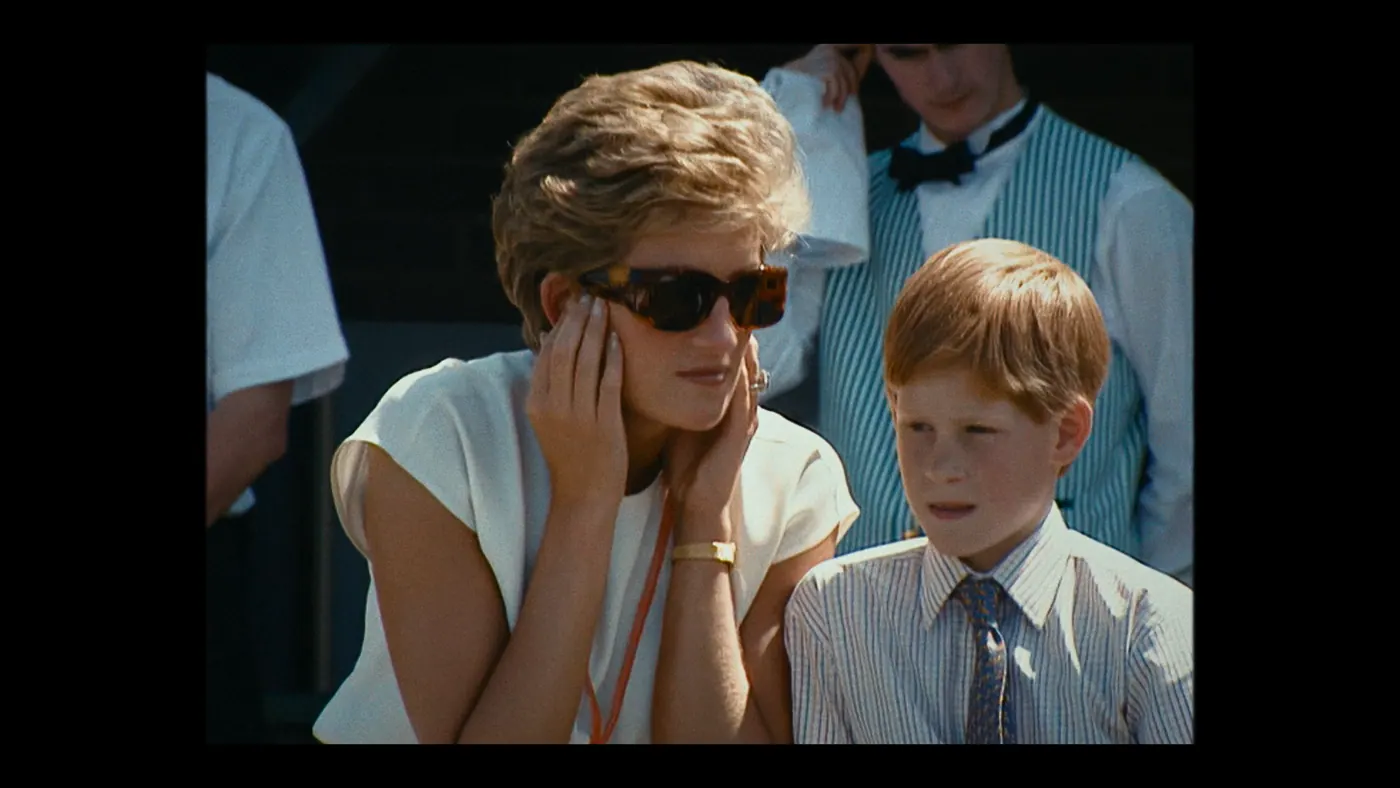 Schumacher ’94 — The Birth of a Legend (2026), Christin Freitag — plan rapproché, jour, extérieur, quatre personnages, soleil direct : chemisier blanc, montre, bague, serviette