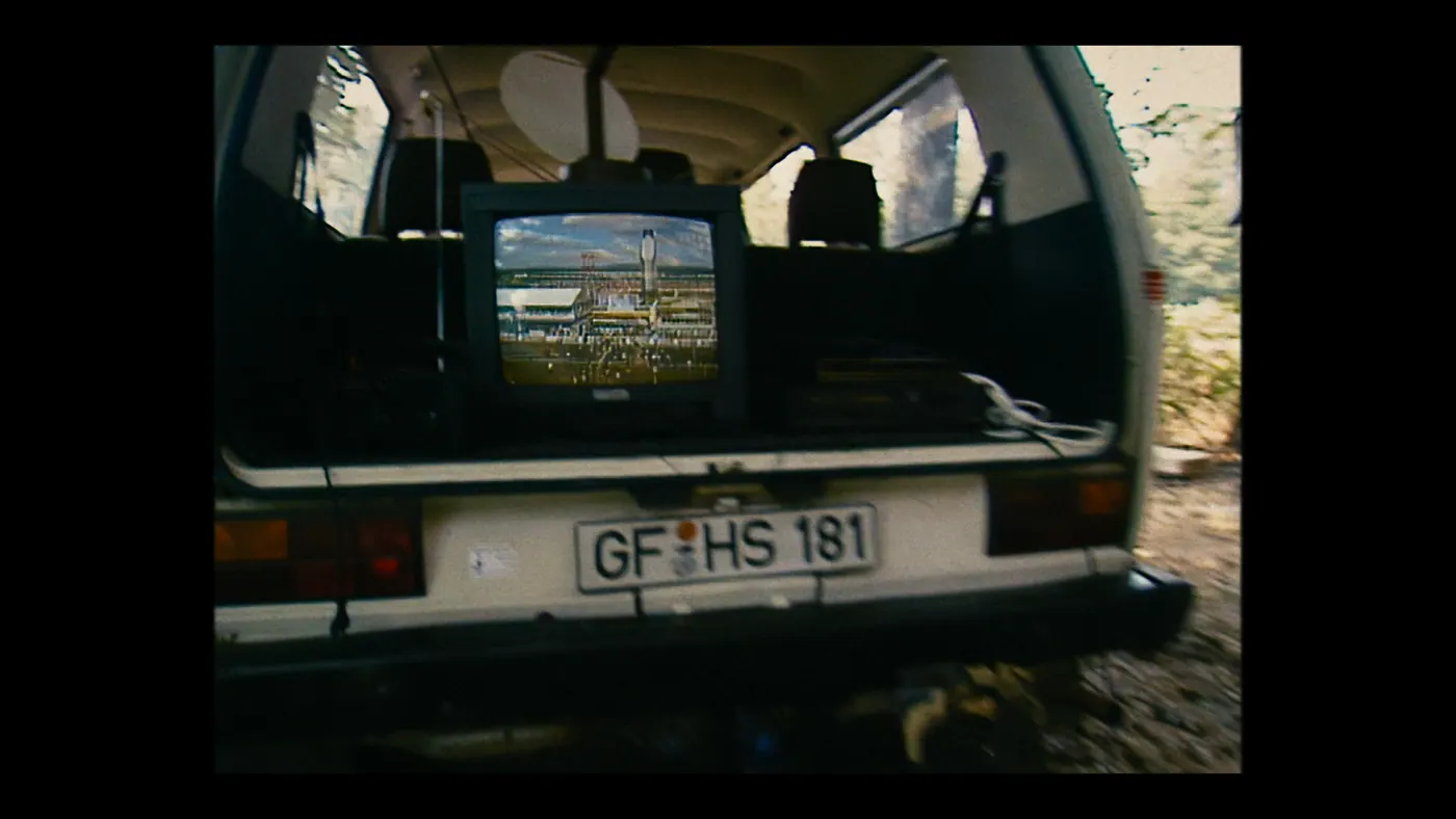 Schumacher ’94 — The Birth of a Legend (2026), Christin Freitag — insert, jour, extérieur, sans personnage : camionnette, téléviseur, plaque d’immatriculation, câble, siège