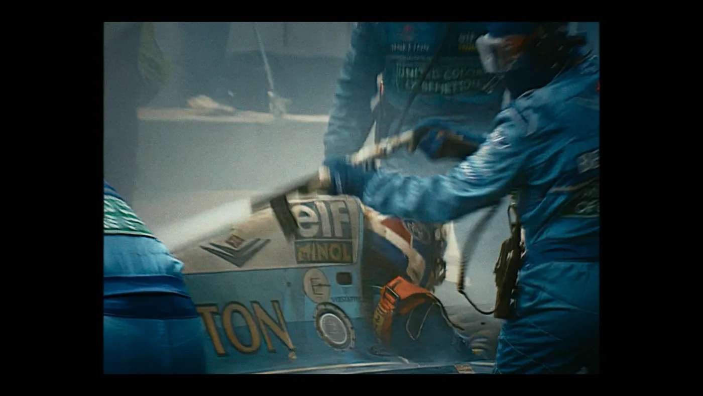 Schumacher ’94 — The Birth of a Legend (2026), Christin Freitag — plan rapproché, jour, extérieur, trois personnages : circuit automobile, combinaison bleue, voiture de course, formule 1