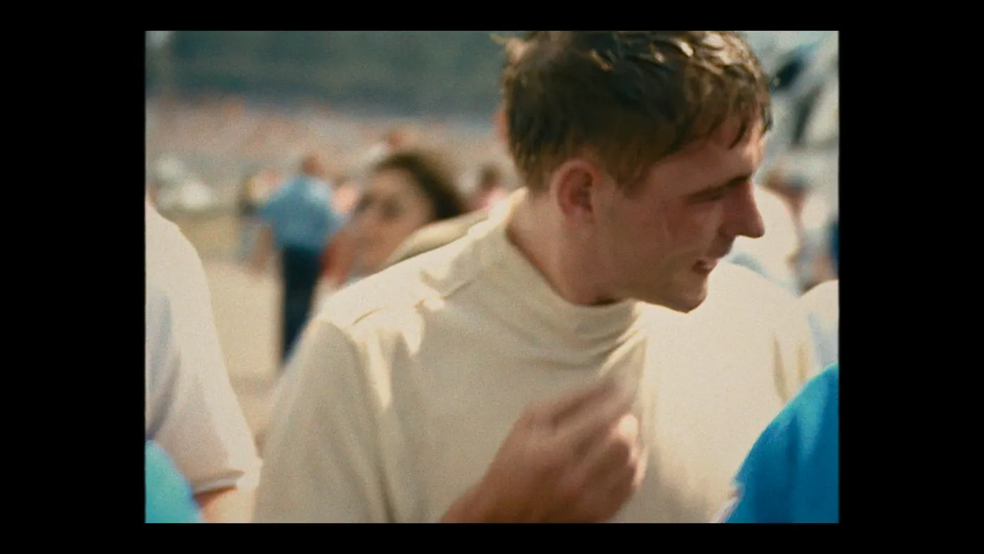 Schumacher ’94 — The Birth of a Legend (2026), Christin Freitag — plan rapproché, jour, extérieur, foule : col roulé blanc