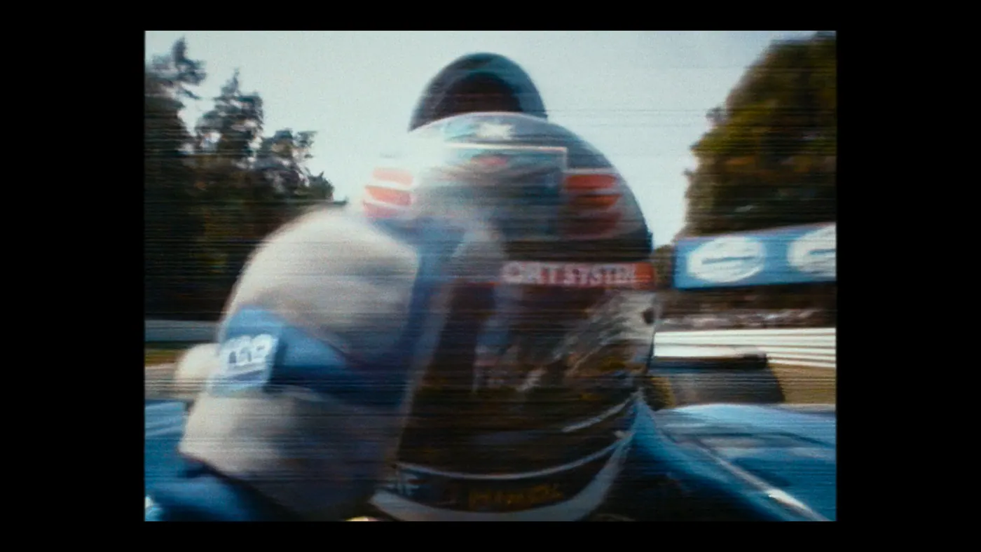 Schumacher ’94 — The Birth of a Legend (2026), Christin Freitag — gros plan, jour, extérieur, un personnage : circuit automobile, voiture de course, formule 1, arbre, panneau publicitaire