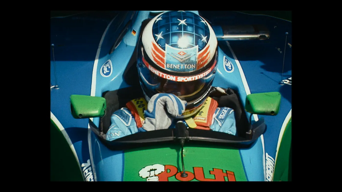 Schumacher ’94 — The Birth of a Legend (2026), Christin Freitag — plan rapproché, jour, extérieur, un personnage, soleil direct : voiture (habitacle), voiture de course, formule 1