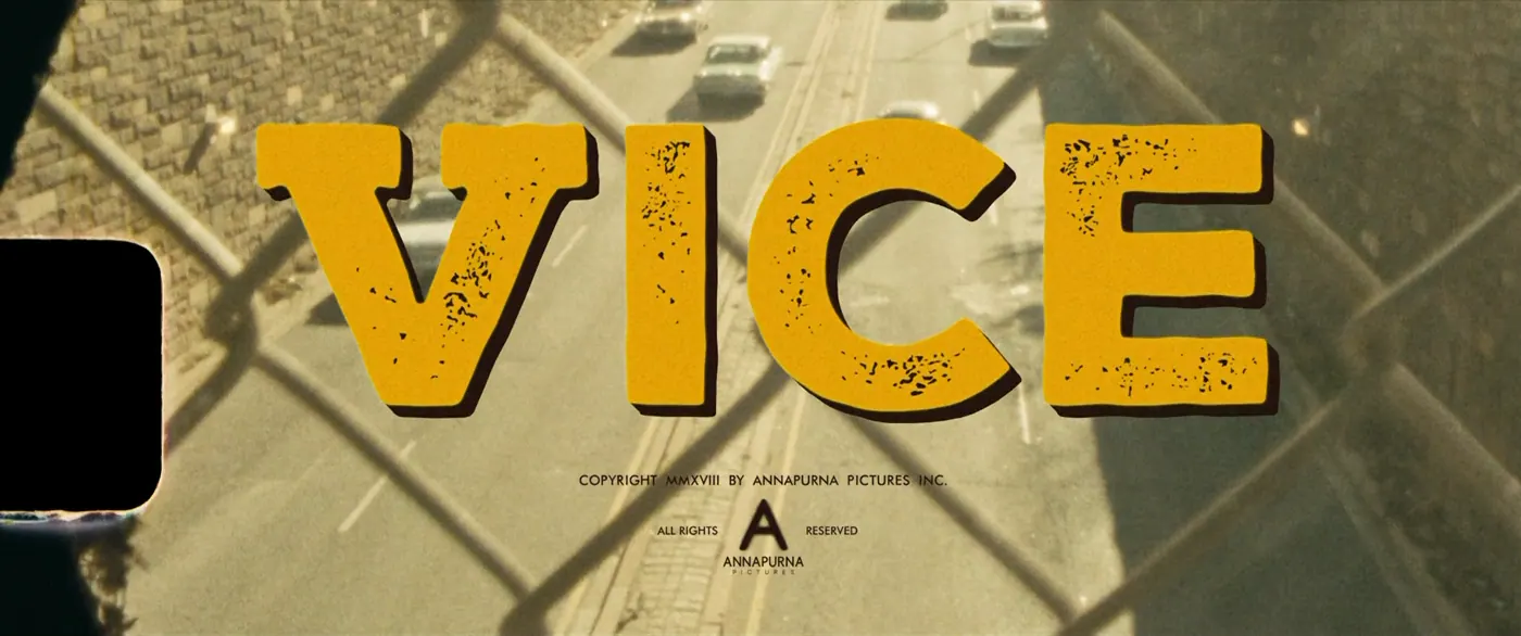 Vice (2018), Adam McKay — plan d’ensemble, jour, extérieur, sans personnage, soleil direct, générique : autoroute, voiture, grillage, pellicule