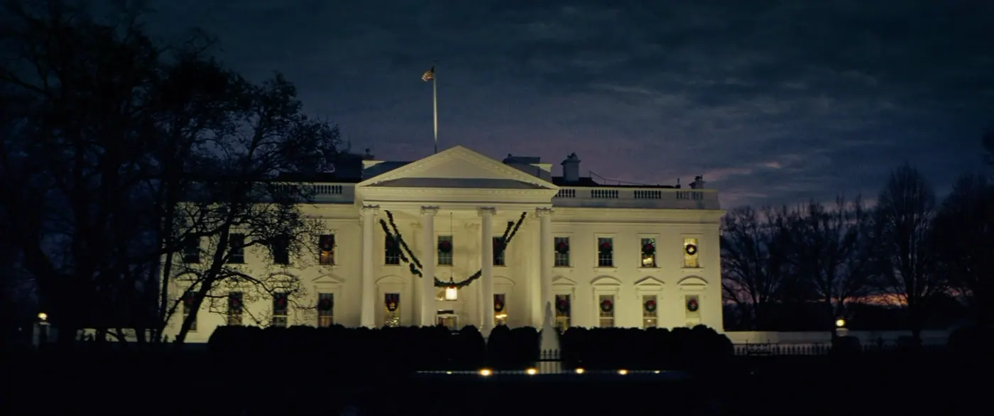 Vice (2018), Adam McKay — plan d’ensemble, aube ou crépuscule, extérieur, sans personnage, lumière chaude, silhouette : palais, jardin, maison blanche, drapeau, couronne de noël, guirlande