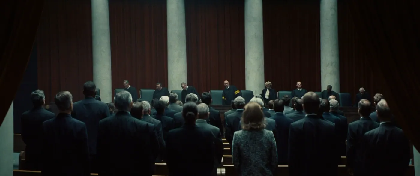 Vice (2018), Adam McKay — plan d’ensemble, intérieur, foule, clair-obscur : tribunal, rideau, colonne, fauteuil, banc, toge, costume