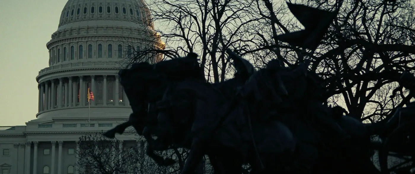 Vice (2018), Adam McKay — plan d’ensemble, aube ou crépuscule, extérieur, sans personnage, silhouette, contre-jour : ville, capitole, dôme, drapeau américain, statue équestre, arbre