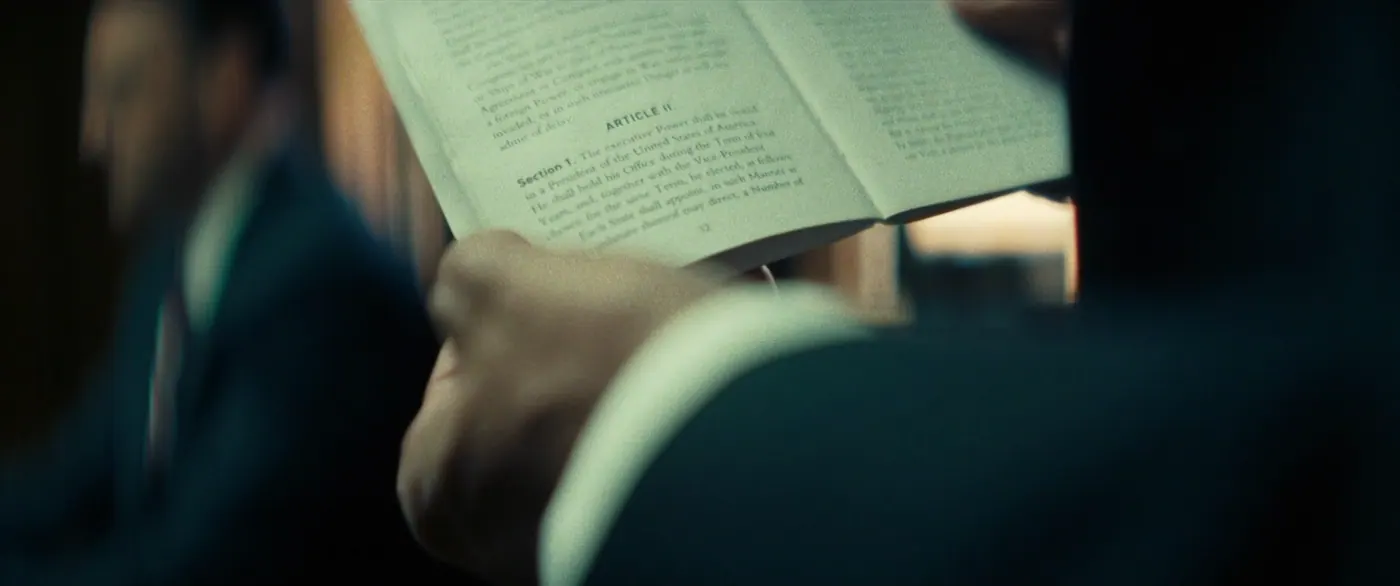 Vice (2018), Adam McKay — très gros plan, intérieur, deux personnages, clair-obscur, lumière froide : livre, constitution, costume, lire