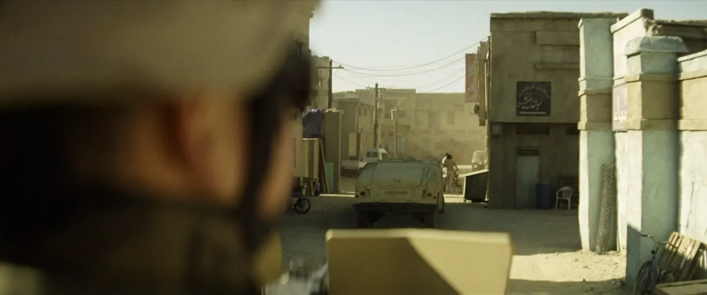 Vice (2018), Adam McKay — plan large, jour, extérieur, deux personnages, soleil direct : rue, ville, humvee, véhicule militaire, vélo, chaise en plastique, poteau électrique