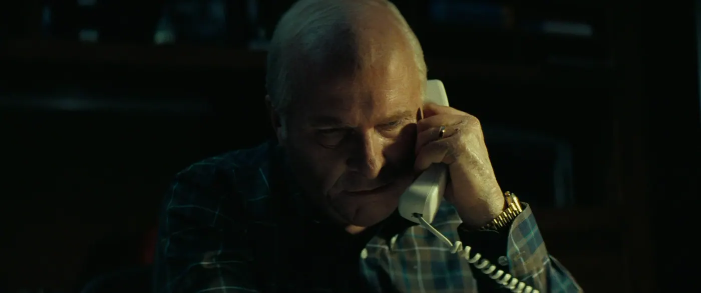 Vice (2018), Adam McKay — gros plan, nuit, intérieur, un personnage, clair-obscur : téléphone fixe, montre, bague, chemise à carreaux, téléphoner
